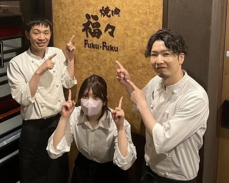 Staff smiling in front of the FukuFuku sign