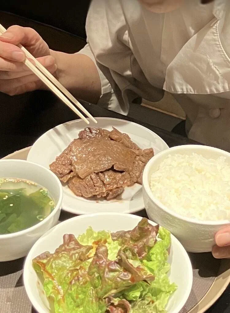 A staff meal of grilled meat with rice, soup, and salad